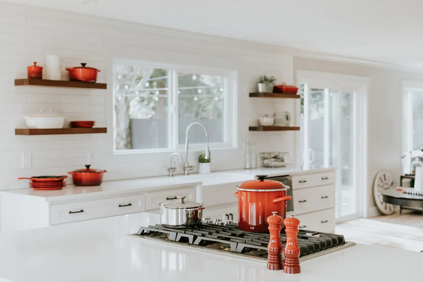 Bright kitchen with floating wood shelves, white cabinets, and a sink